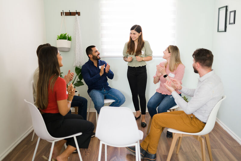 A bright, warm-lit room with people listening to one another with relaxed posture