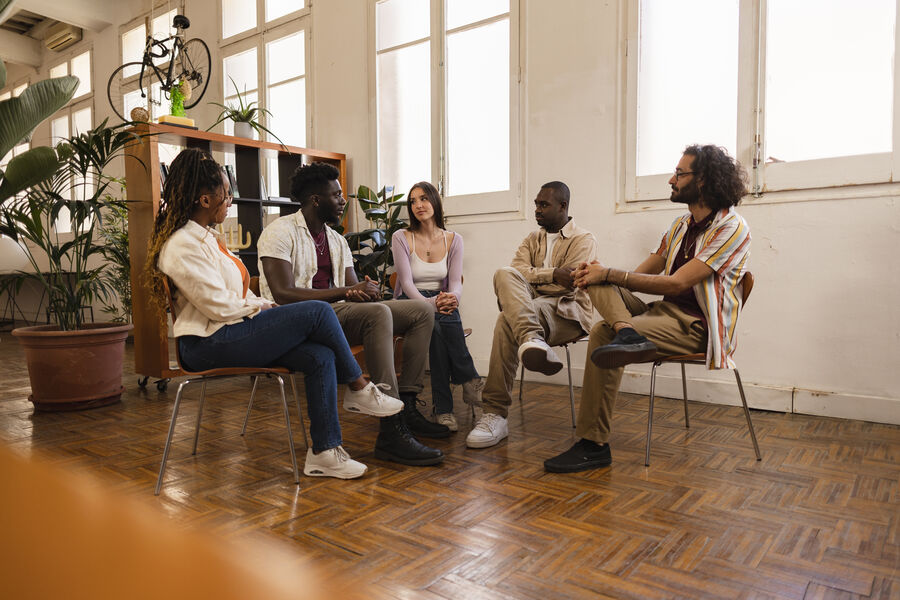 A group of adults sitting together indoors having a structured conversation