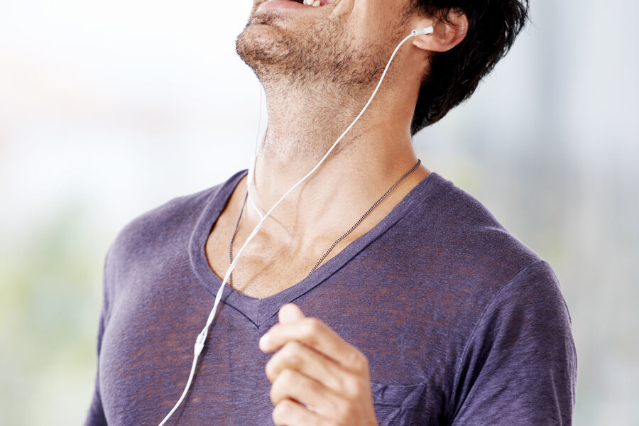 A man laughing while listening to music with headphones
