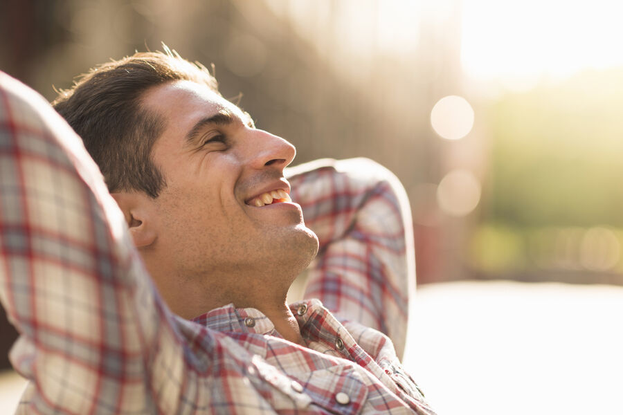 A man reclining outdoors, calm, eyes half-closed